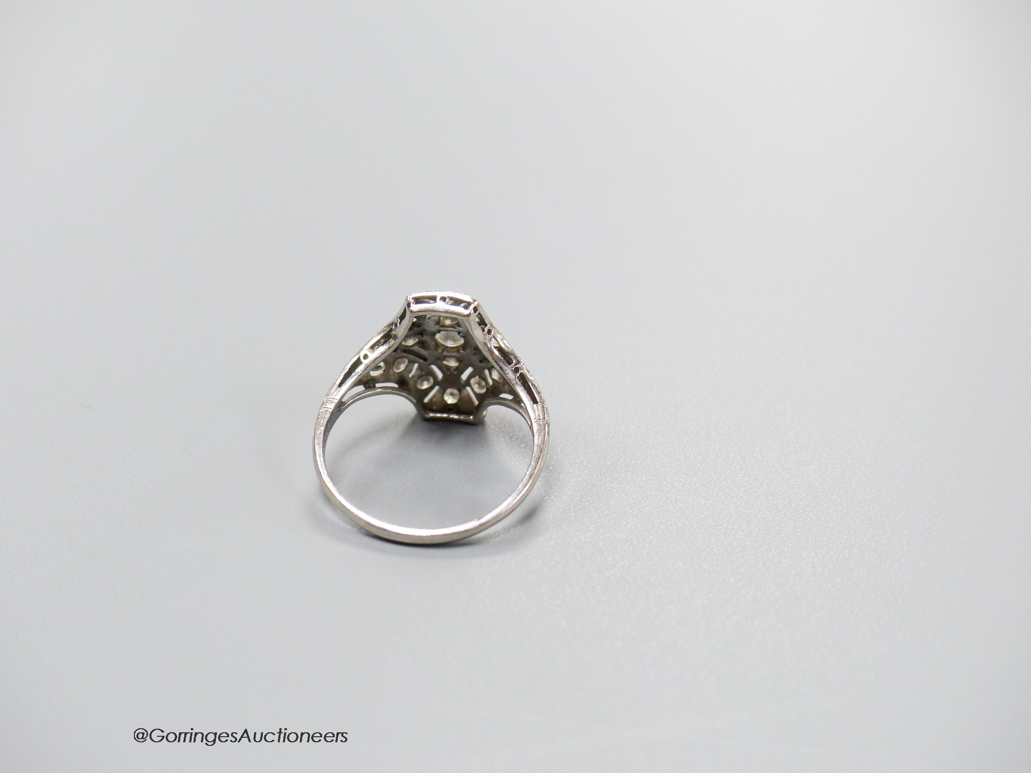 A 1920's pierced white metal and diamond cluster dress ring, size M, gross 3.5 grams.